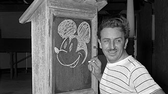 photo of a young Walt Disney drawing Mickey Mouse on a chalkboard
